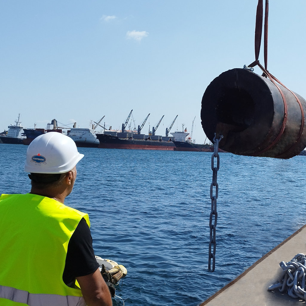 Marine engineer overseeing port infrastructure installation with cargo ships in the background, demonstrating mooring system optimization and corrosion protection solutions